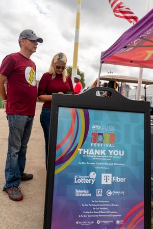 Festival sponsor banners and signage displayed at an outdoor event showing logos for Lottery and T-Fiber partners.