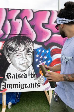 Street art mural featuring American flag and text against pink and black background.
