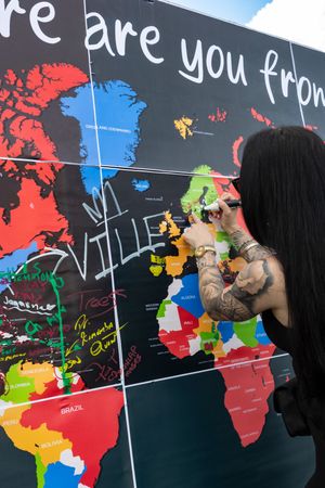 Interactive world map display where visitors can mark their country of origin.