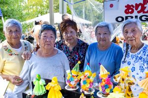Group wearing matching blue and white outfits with decorative yellow flowers at an outdoor event.