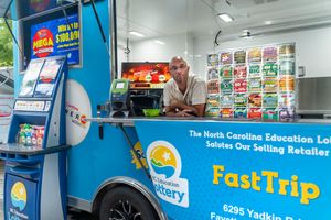 Interior view of a colorful convenience store with lottery signage and snack displays.