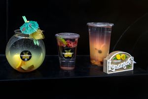 Assorted tropical drinks with umbrellas and garnishes displayed on a dark surface.