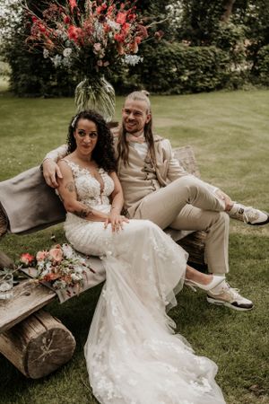 Bruidspaar zit op een bankje tijdens hun ceremonie