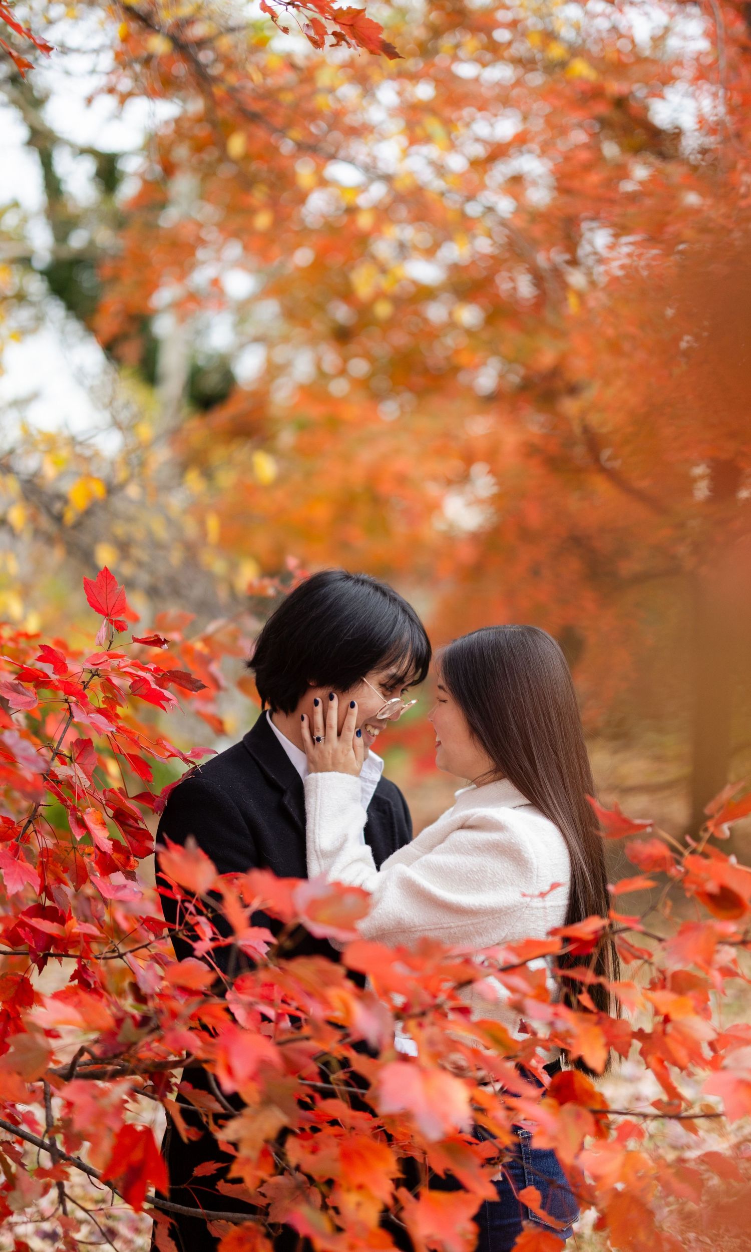 Couple sharing intimate moment on rooftop during sunset with city skyline backdrop.