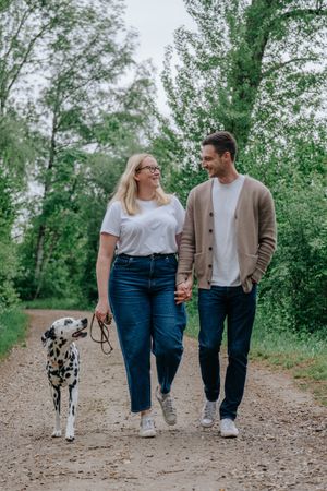 Mensch-Hund-Fotografie: Paar geht gemeinsam mit seinem Hund über einen Weg im Grünen bei Pfaffenhofen a. d. Ilm.