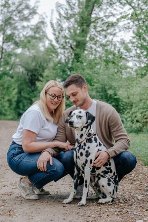 Mensch-Hund-Fotografie: Paar kniet im Freien bei seinem Hund, ruhige Aufnahme im Raum Dachau.