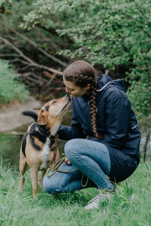 Mensch-Hund-Fotografie: Frau ist auf Augenhöhe mit ihrem Hund im Grünen, ruhiger Moment im Umland von München.
