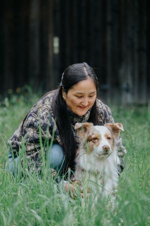 Mensch-Hund-Fotografie: Frau liegt mit ihrem Hund im hohen Gras, ruhiger Moment im Grünen bei Hohenkammer.