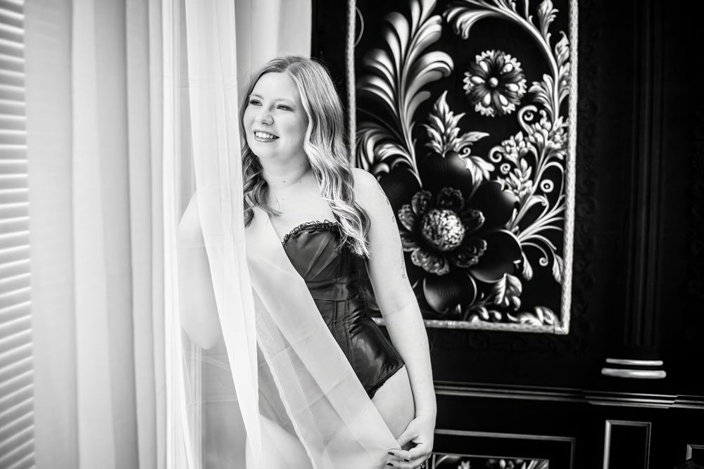 Black and white portrait session with floral wallpaper background.