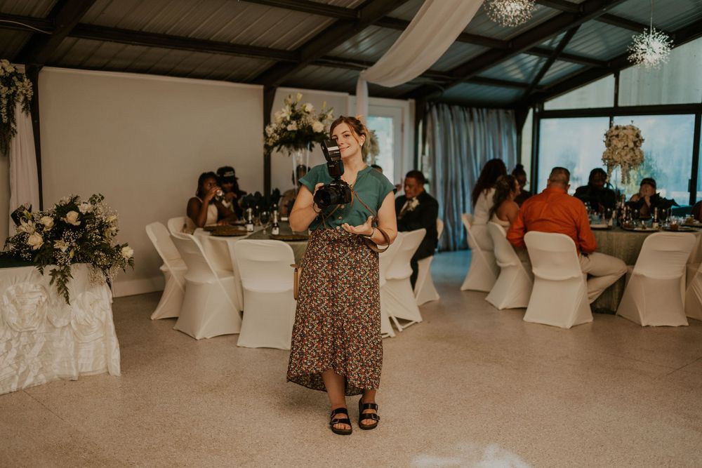 Interior view of an event venue with white chairs and decorative elements.