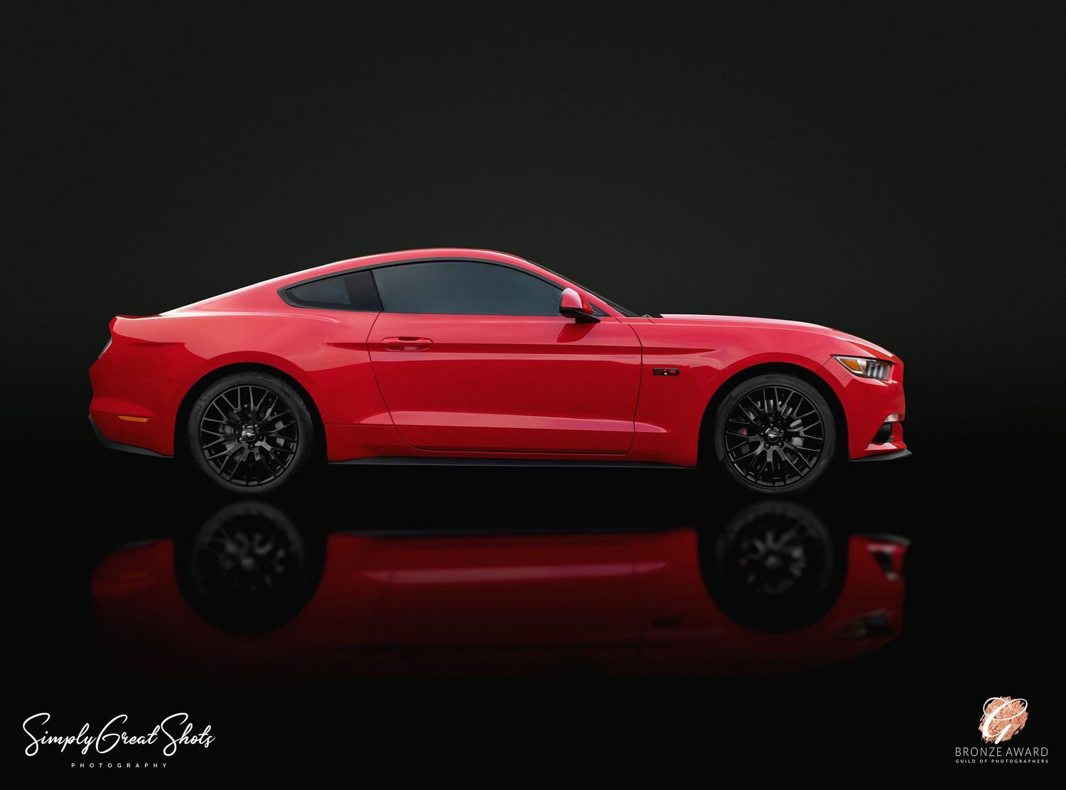 A side on photograph of a red Ford Mustang complete with a reflection