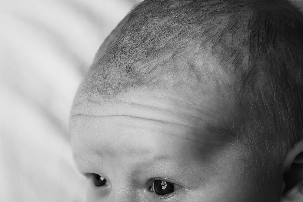Small details of a newborn baby's forehead in black and white portrait