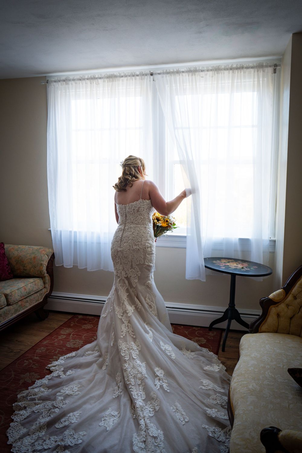 A series of photos showing a wedding dress train being arranged in a sunlit room with white curtained windows.