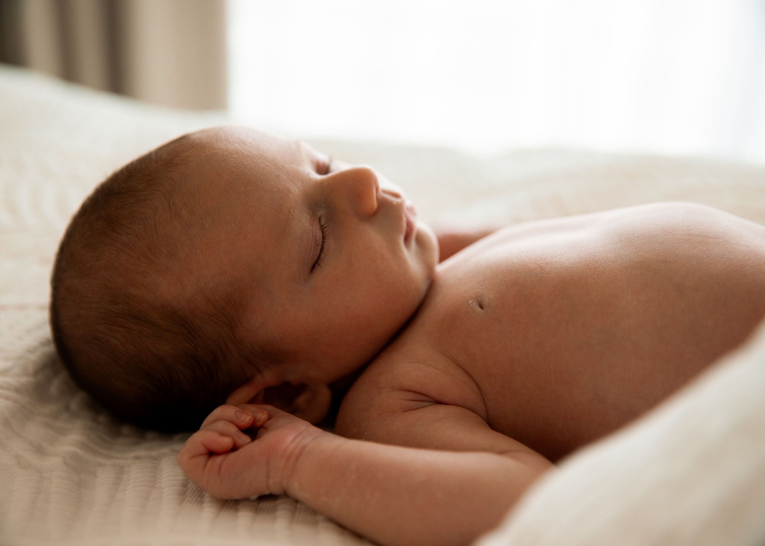 Natural newborn photography portrait of sleeping baby captured at client's home in Dubai
