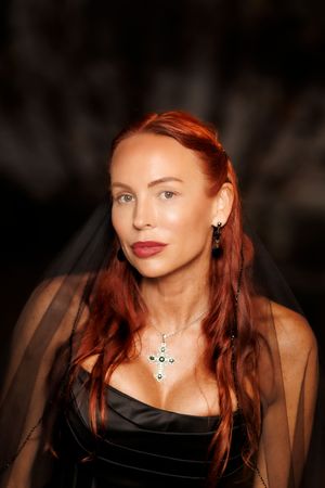 A series of portraits showing a woman with vibrant red hair wearing a black top against a dark background.