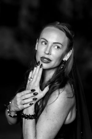 Black and white portrait series showing hands with dark nail polish covering expressions in dramatic lighting.
