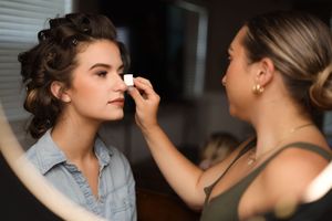 Professional makeup artist applies finishing touches of bridal makeup in a series of preparation shots.