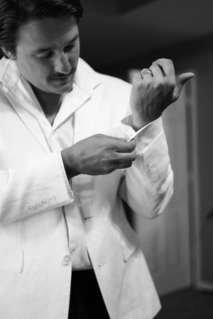 Three black and white cropped photos show intimate close-up moments between partners in matching white attire.