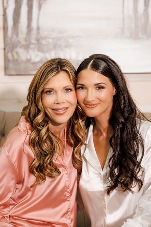 Two friends in silk robes smile together in a series of casual portrait photos with soft lighting.