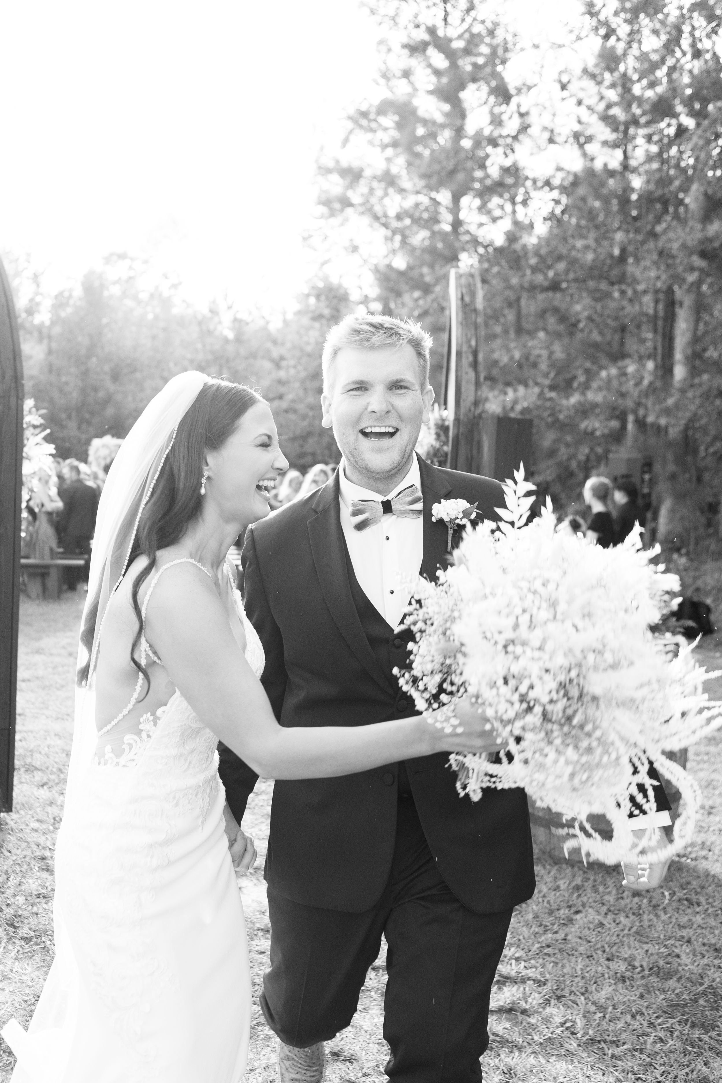 Black and white wedding photo series showing joyful candid moments between a couple in formal attire outdoors.