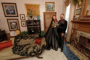 Vintage home interior decorated with multiple framed artworks and ornate furnishings creates an eclectic gallery wall effect.