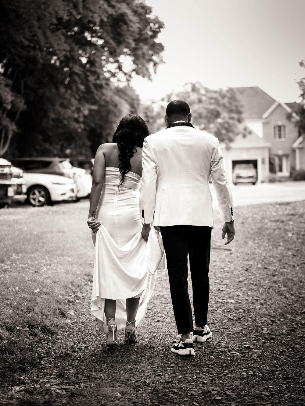 Black and white series of images showing a couple walking together on a grassy path in casual attire.