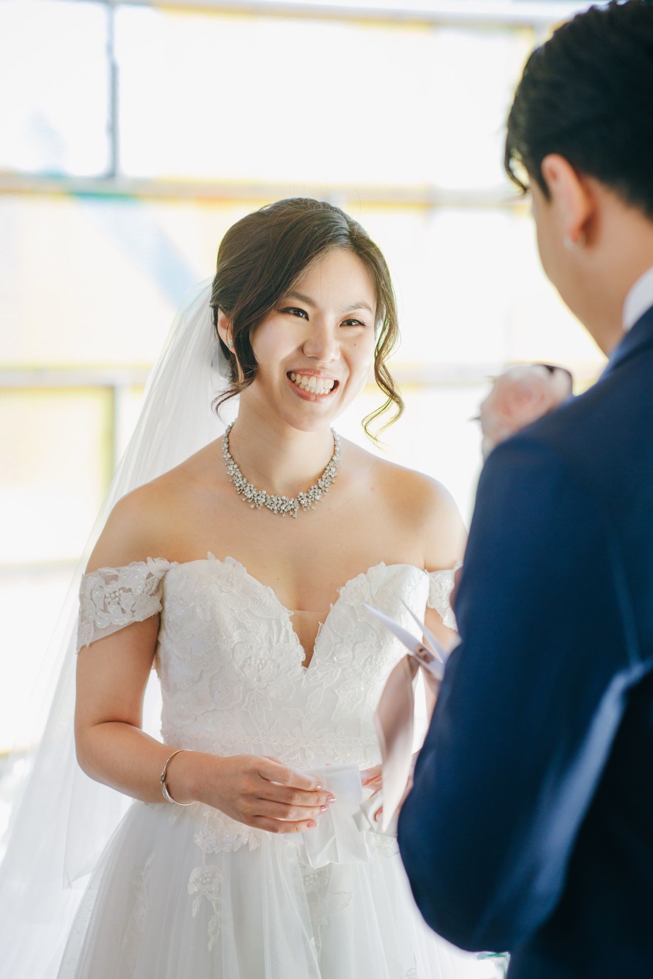 Bride laughing with a tissue in her hand during emotional wedding vows in Vancouver