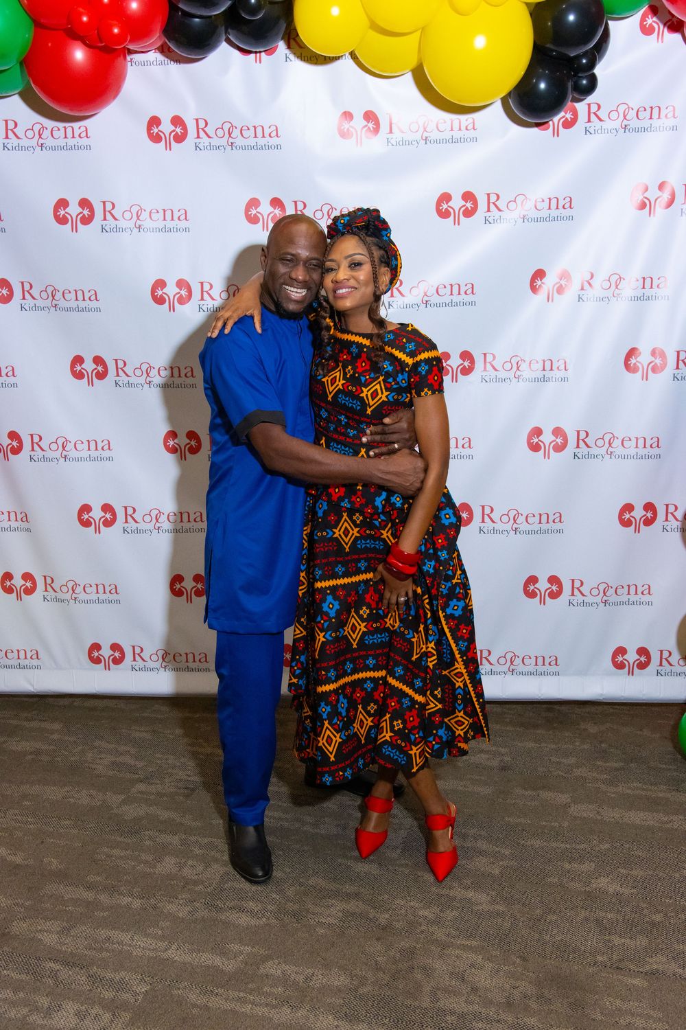 Couple posing together at Rorena Kidney Foundation event, man in blue outfit and woman in colorful African print dress.