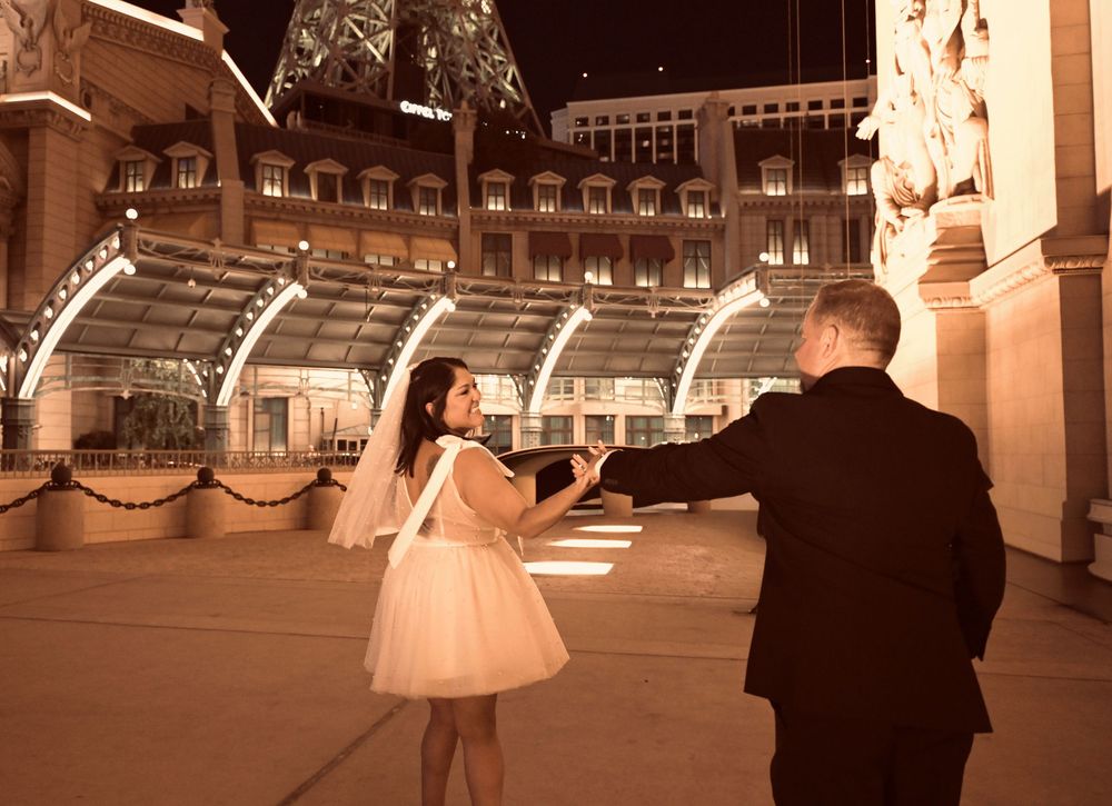 Bride and groom dancing at night near the Eiffel Tower at Paris Las Vegas hotel and casino.