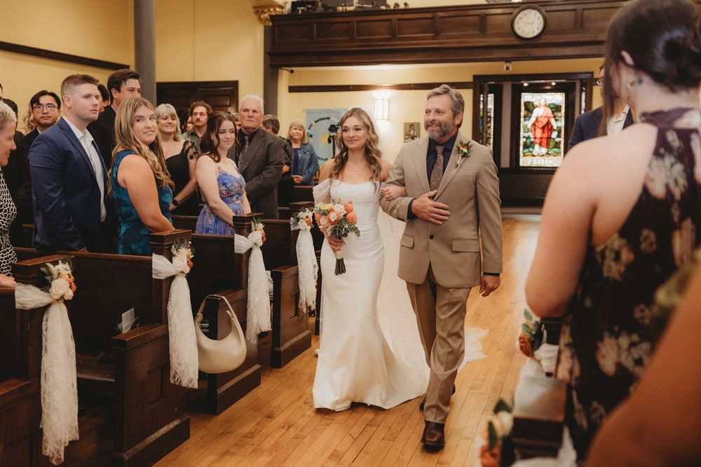 Bride walks down the aisle with her father in a charming rustic church wedding ceremony.