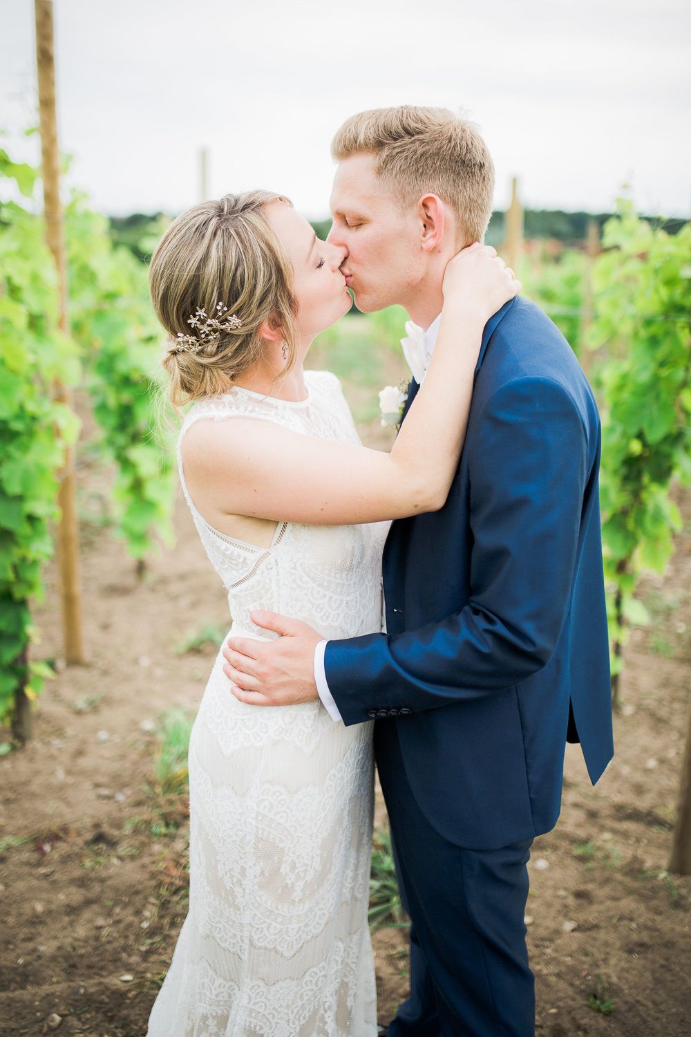 Brudepar kysser i en vinmark – bryllupsfoto af Martin & Louise