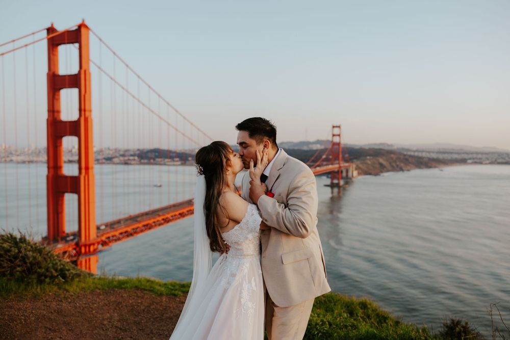 couple kissing each other with the golden gate bridge behind them at battery spencer on their san francisco elopement day