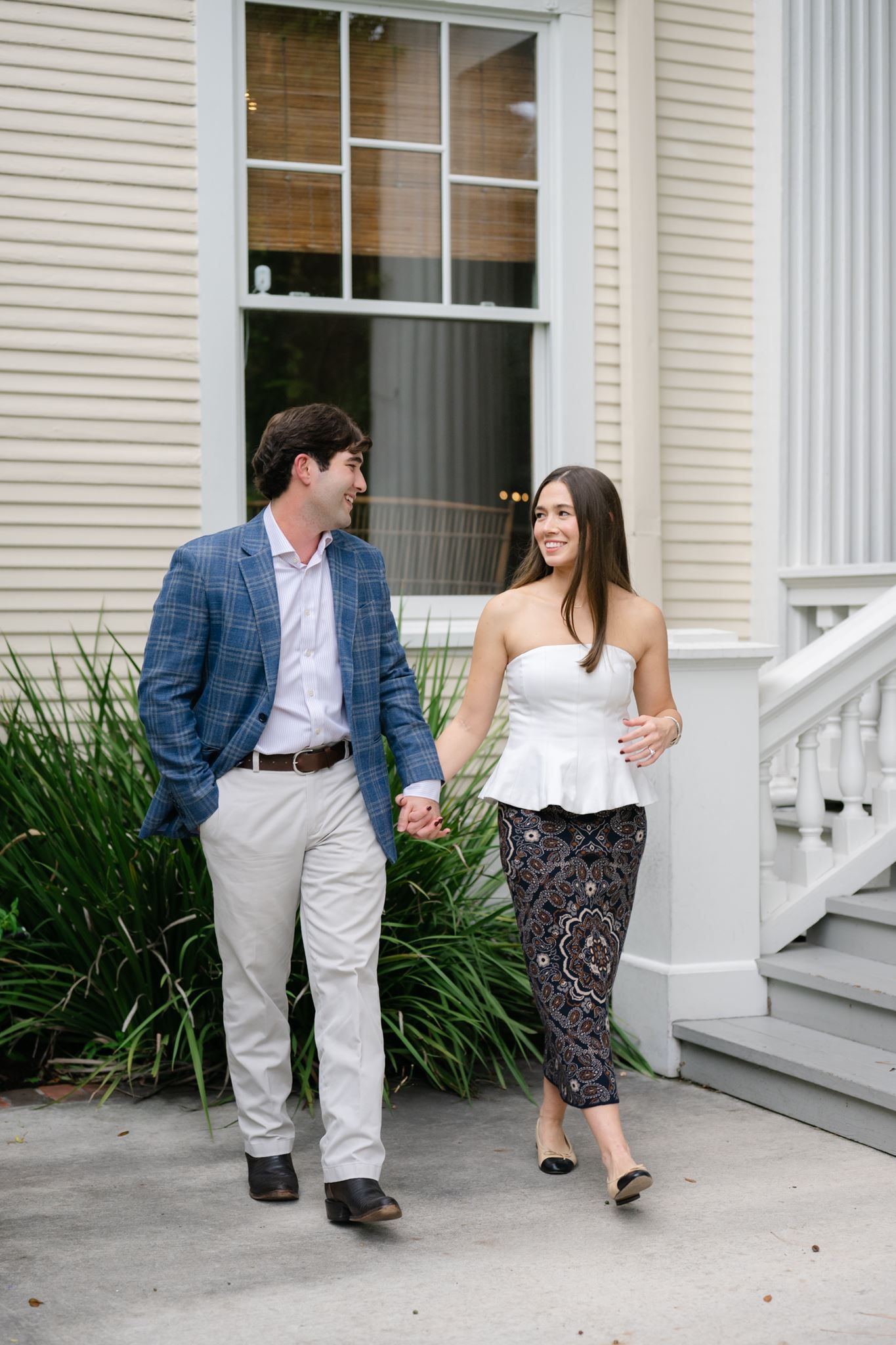 Guy and girl holding hands and smiling at each other.