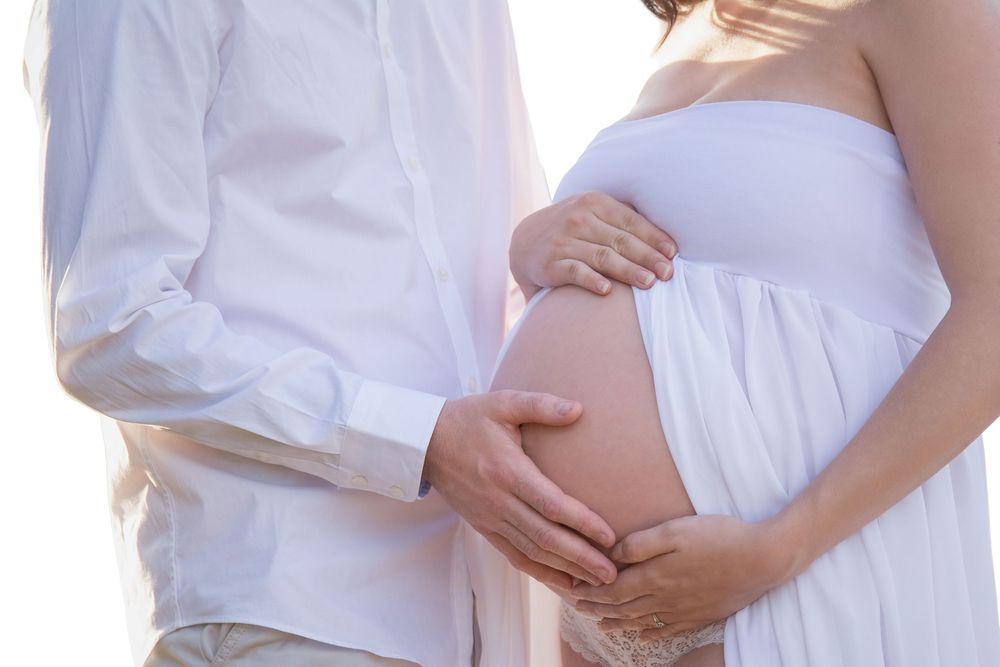 a close up shot of a couple holding the mothers pregnant belly