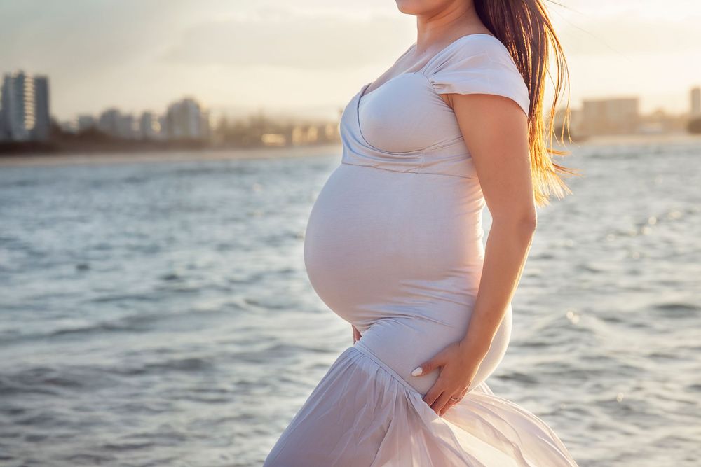 sunset maternity session mother in a grey tight fitting silhouette style dress