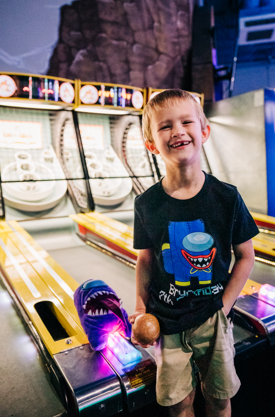 Lake Worth Beach birthday photos of a smiling boy playing skee-ball at Fun Depot arcade.