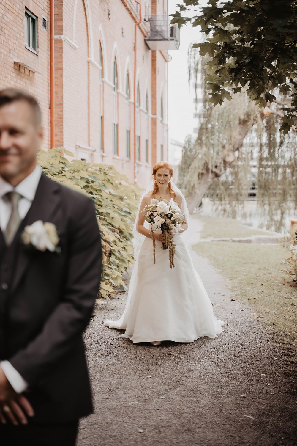 First look fotografering vid Strömsparken I Norrköping, bruden går mot brudgummen som står med ryggen till och väntar.