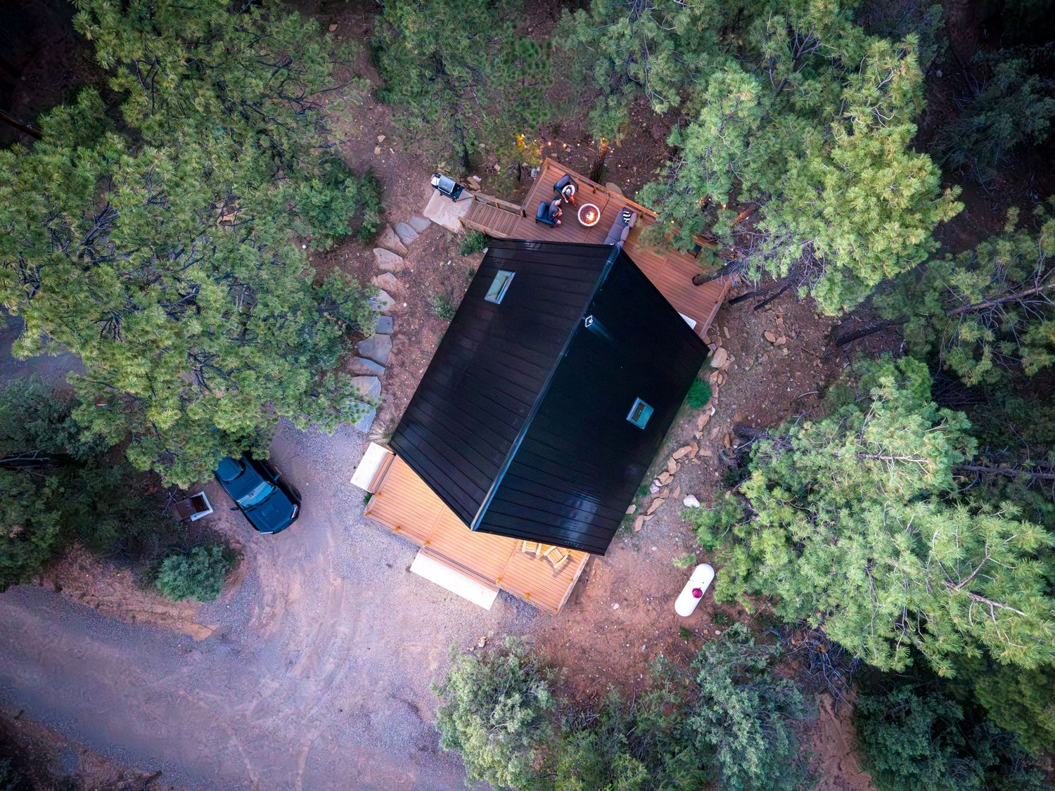 Aerial/drone top down shot of a couple sitting by the firepit at a luxury vacation rental in Durango, CO.