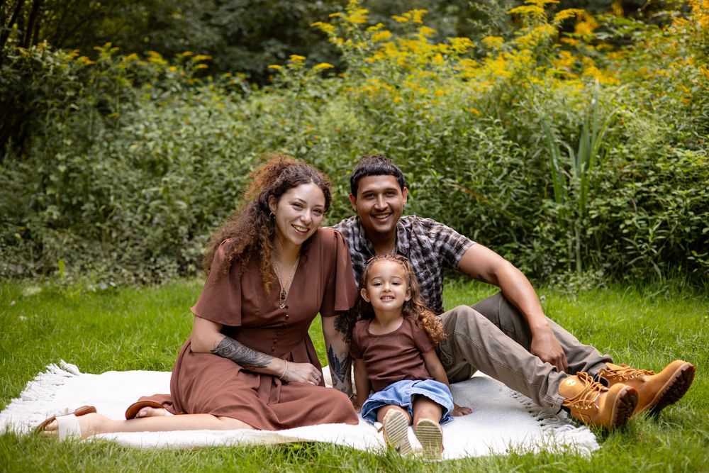 Family sitting on a blanket together during an outdoor session in Wilbraham, MA