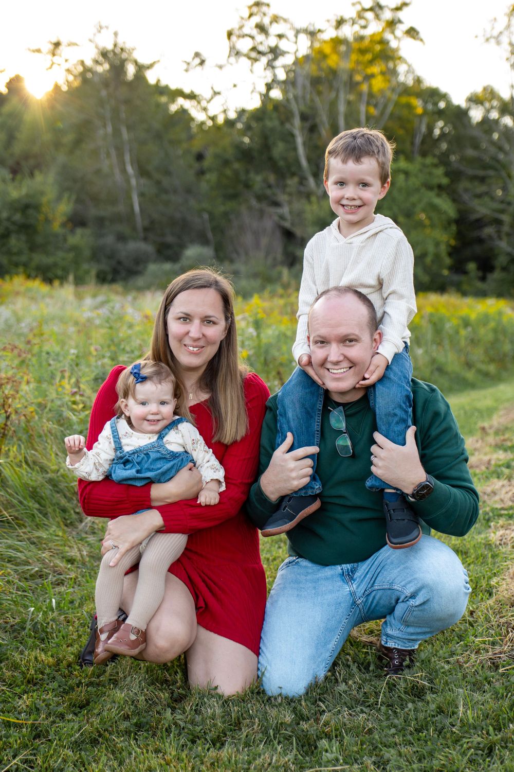 Family of four smiling for a portrait during golden hour photo session