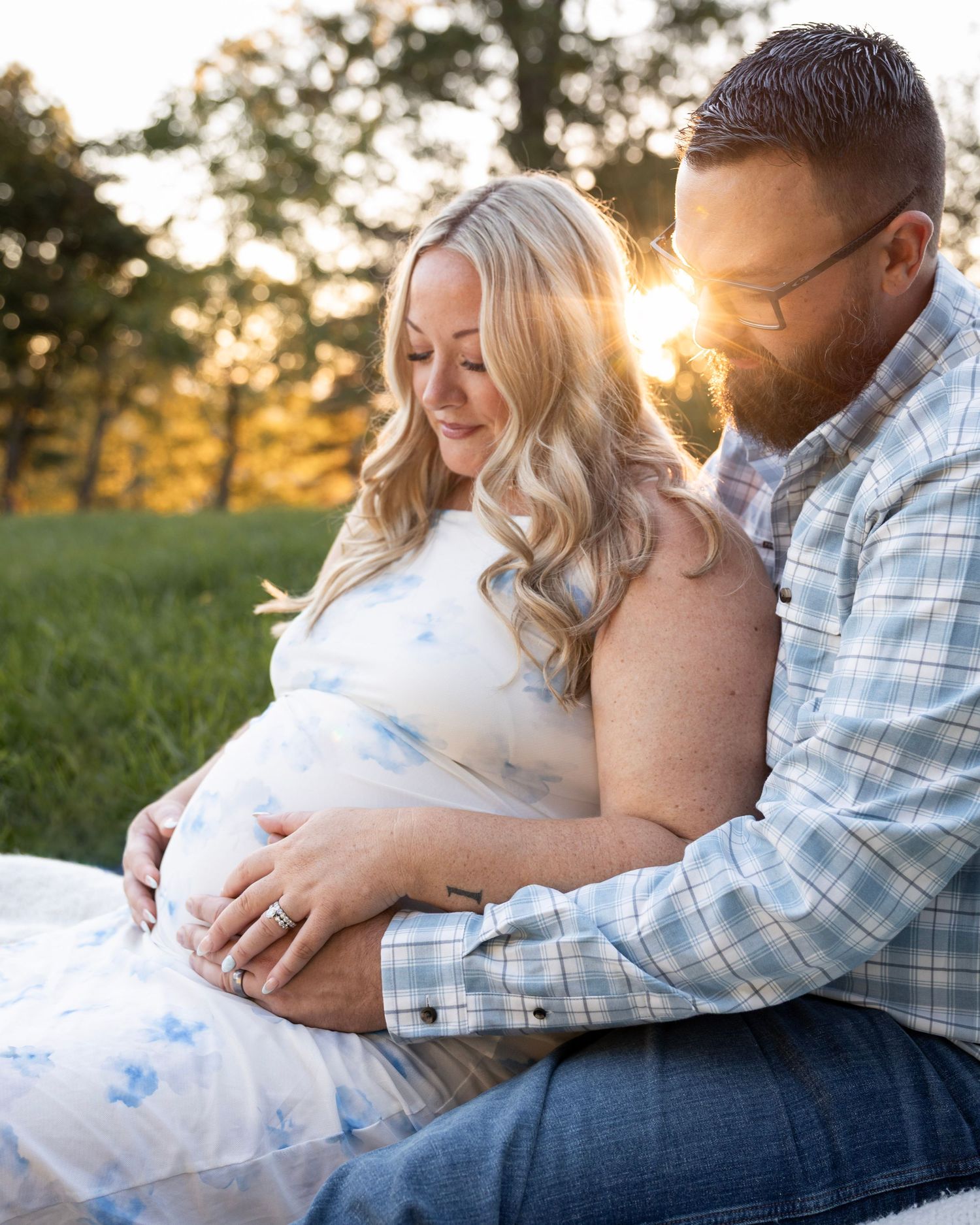 Couple embracing during a golden hour maternity session