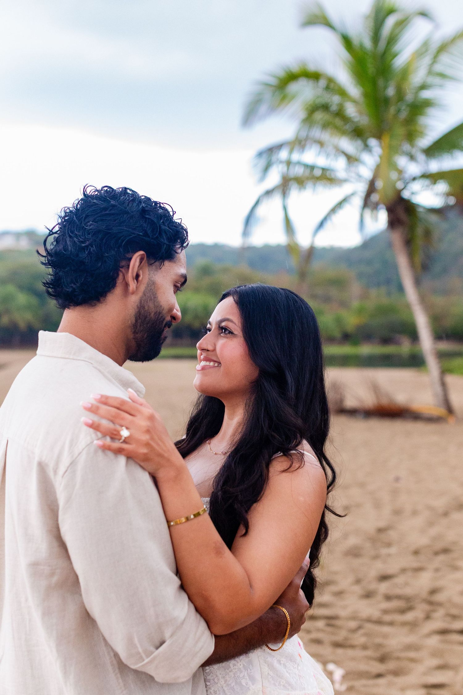 Engagement portrait on the beach. Man and woman and palm tree. Playa Guajataca, Isabela, Puerto Rico.
