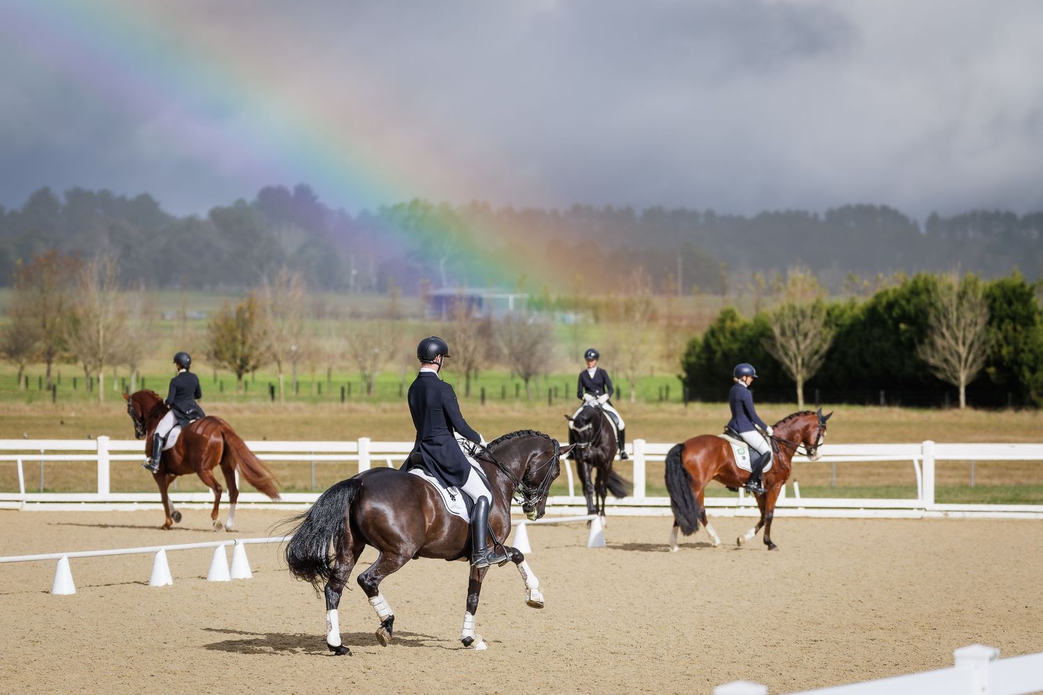 Competitors warming up under a rainbow at Bowral Dressage Club. © Simon Scully, 2026.