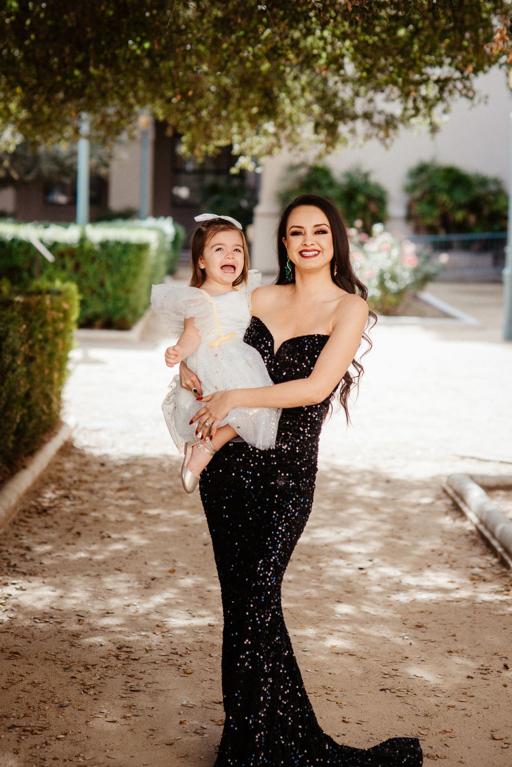 A joyful moment captured outdoors with playful interaction against a garden backdrop.