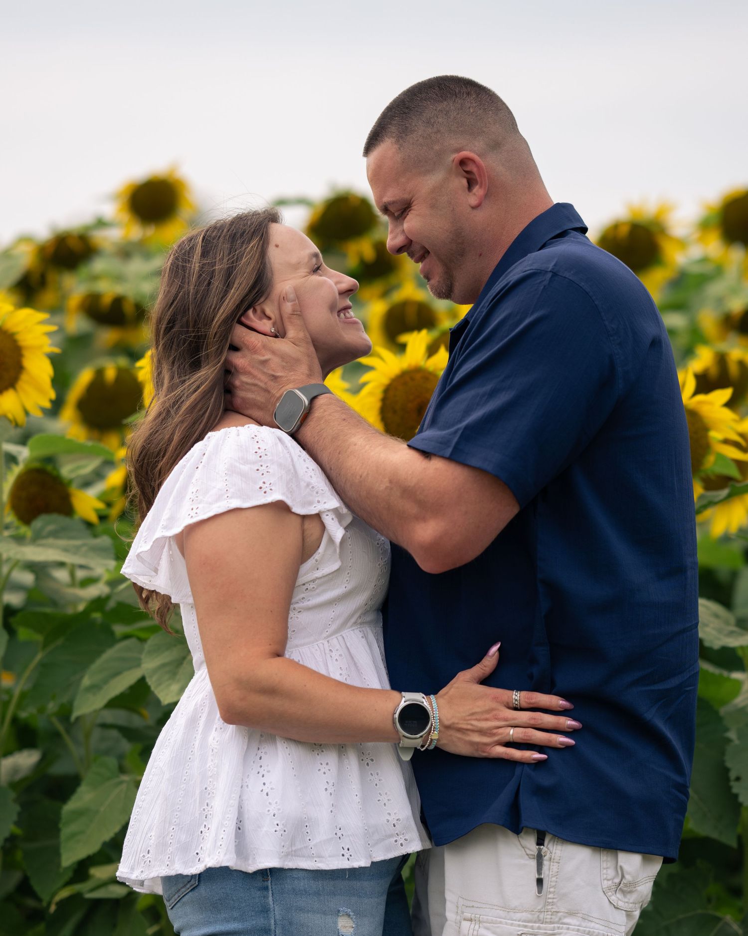 Couple sharing a romantic moment in a vibrant sunflower field for New Hampshire sunflower mini sessions