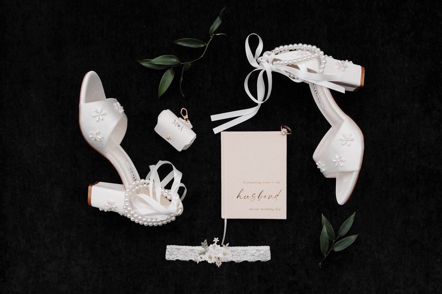 Elegant bridal flat lay with white heels, lace garter, pearl accessorie at McCormick Woods Golf Club for Mayella and Andrey's wedding.