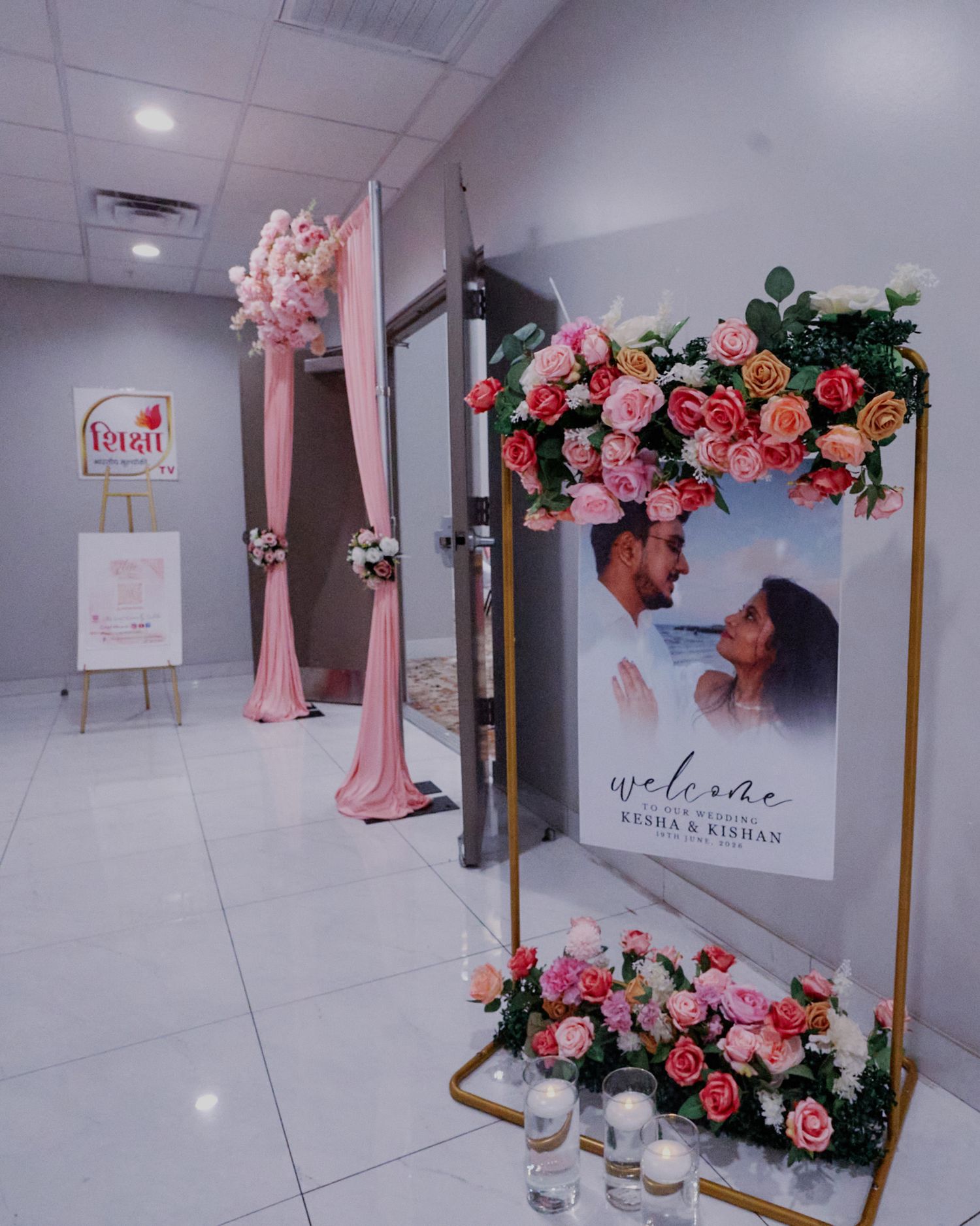 Elegant wedding welcome display with pink floral arrangements for Kisha and Kishan's celebration.