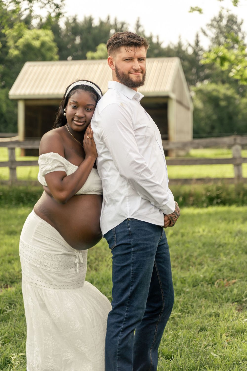 Maternity photo shoot of mom and dad to-be in a horse pasture.
