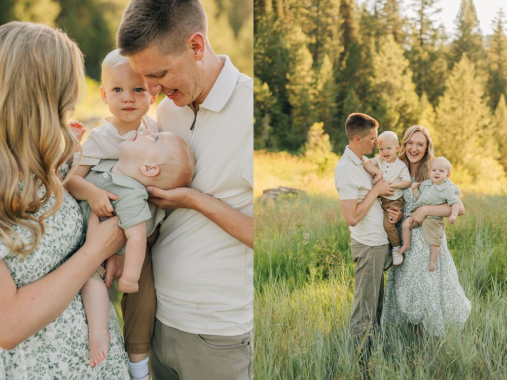 Family of four poses in a sunlit meadow, parents holding two young children in coordinating neutral outfits.