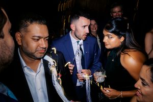 Group of elegantly dressed guests socializing at an upscale evening party event.
